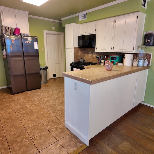 kitchen featuring backsplash, black appliances, white cabinets, ornamental molding, and kitchen peninsula