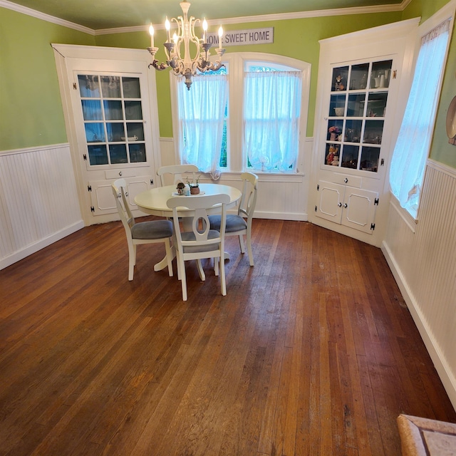 dining space featuring dark hardwood / wood-style floors, vaulted ceiling, crown molding, and a chandelier