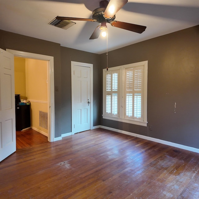 unfurnished bedroom featuring ceiling fan and dark hardwood / wood-style flooring