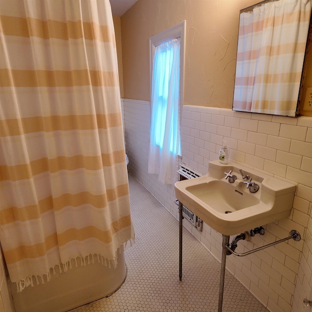 bathroom featuring tile patterned floors, sink, and tile walls