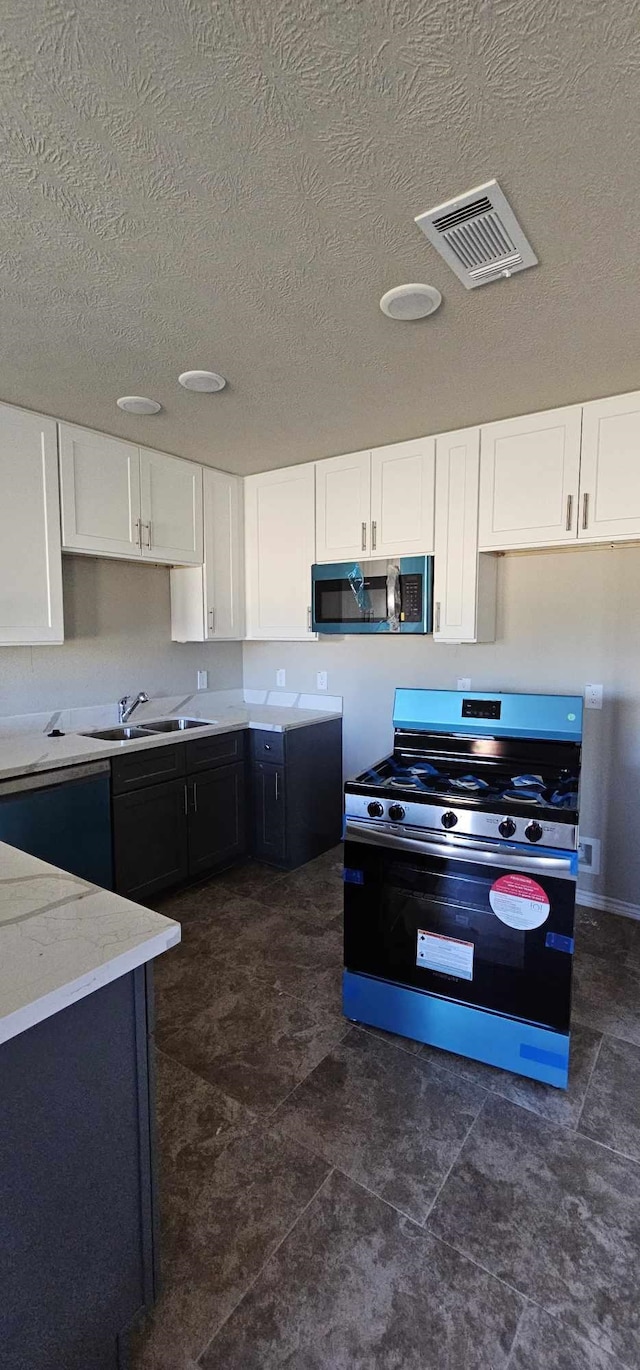 kitchen featuring light stone countertops, sink, white cabinets, and appliances with stainless steel finishes