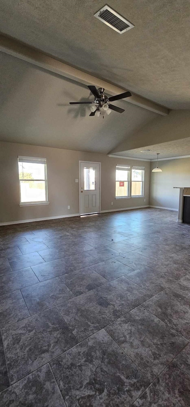 empty room with vaulted ceiling with beams, ceiling fan, plenty of natural light, and a textured ceiling