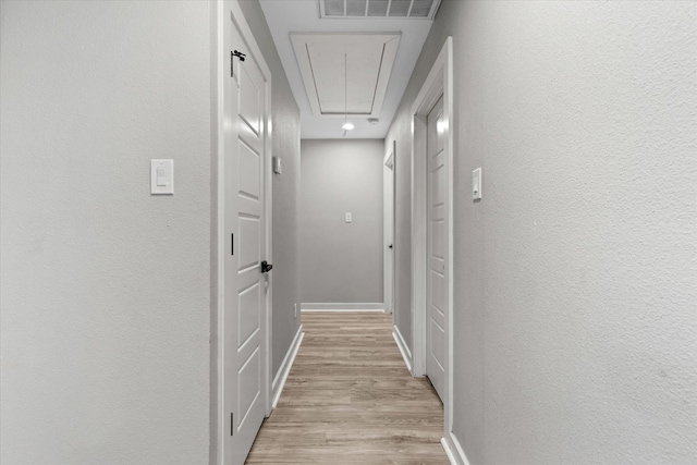 13370 Capital Dr, Bevil Oaks, TX 77713 - corridor featuring attic access, light wood-style floors, and baseboards