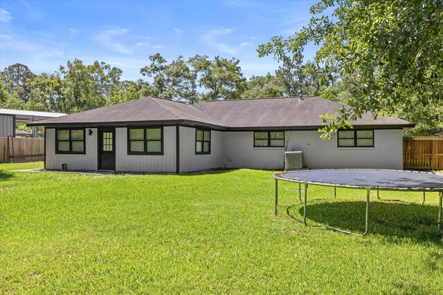 13370 Capital Dr, Bevil Oaks, TX 77713 - back of house featuring a trampoline, central AC, and brick siding