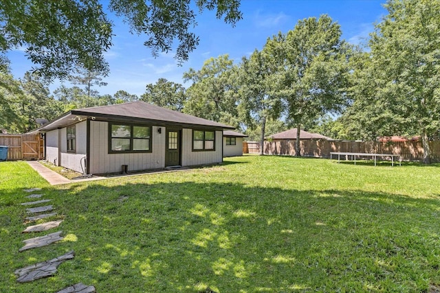 13370 Capital Dr, Bevil Oaks, TX 77713 - rear view of house with a trampoline