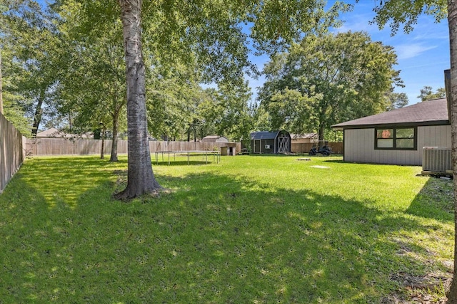 13370 Capital Dr, Bevil Oaks, TX 77713 - view of yard featuring a trampoline, an outbuilding, central AC, and a shed