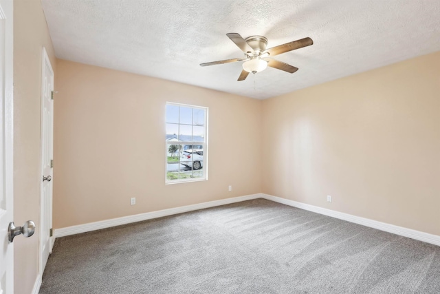 carpeted spare room featuring ceiling fan, a textured ceiling, and baseboards