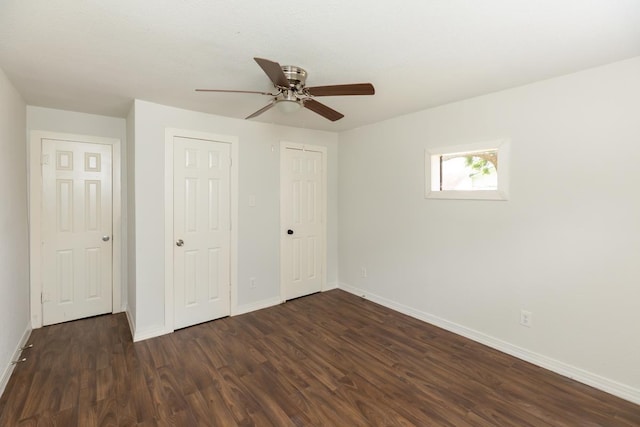 unfurnished bedroom with dark wood-style flooring and baseboards