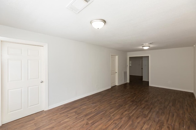 unfurnished room with dark wood-style floors and baseboards