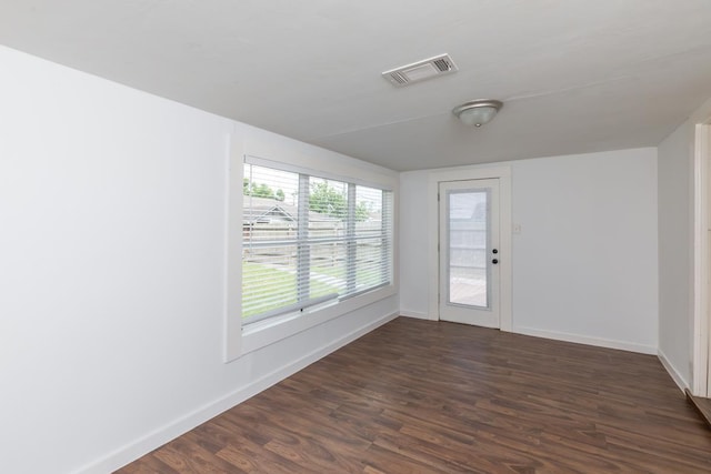 spare room with dark wood-style floors and baseboards