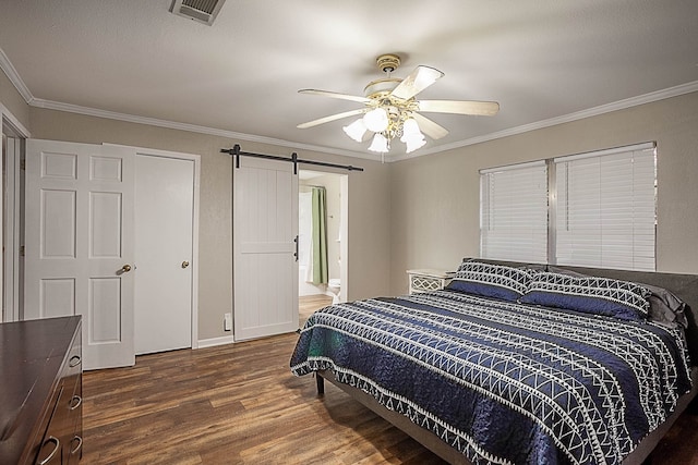 bedroom featuring a barn door, ceiling fan, dark hardwood / wood-style floors, and ornamental molding