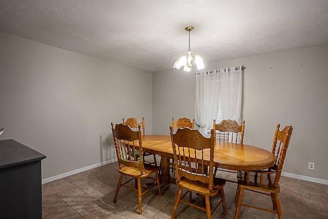 dining space with a textured ceiling and a notable chandelier