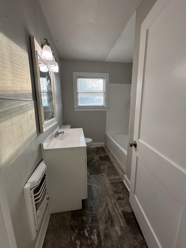 bathroom featuring vanity, heating unit, and toilet