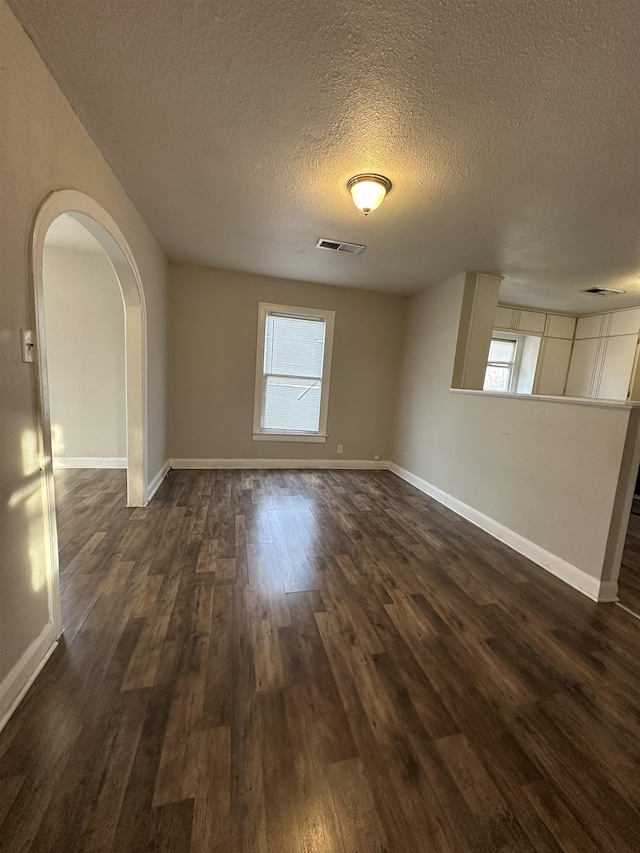 spare room with dark hardwood / wood-style floors and a textured ceiling