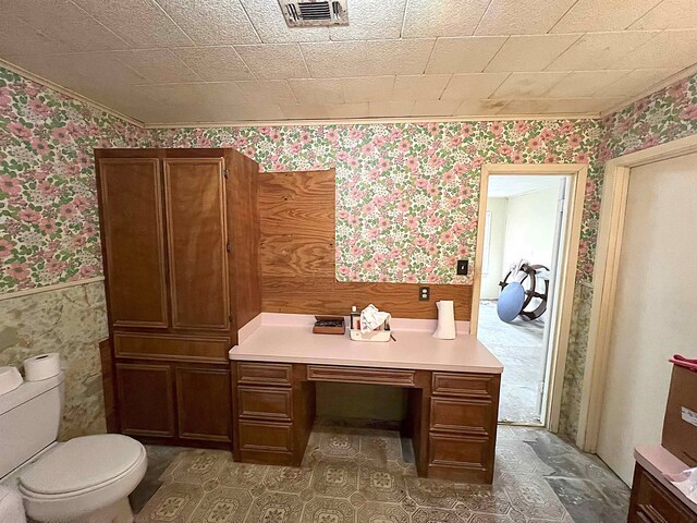 207 Elm St, Silsbee, TX 77656 - bathroom with wallpapered walls, a wainscoted wall, toilet, and ornamental molding