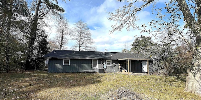 207 Elm St, Silsbee, TX 77656 - back of property featuring central AC unit, board and batten siding, and a lawn
