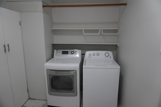 washroom featuring separate washer and dryer and cabinets