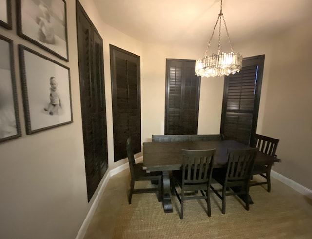 dining space featuring baseboards and an inviting chandelier