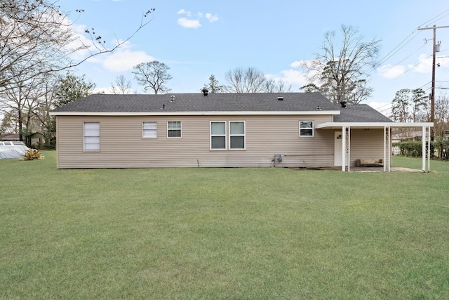 back of property featuring a lawn and a shingled roof