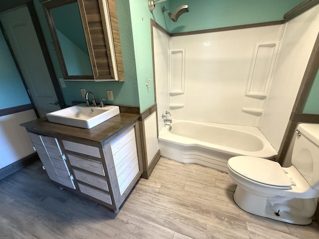 full bathroom with washtub / shower combination, hardwood / wood-style floors, vanity, and toilet