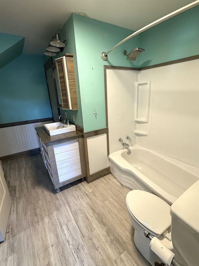 full bathroom with hardwood / wood-style flooring, vanity, toilet, and shower / bath combination