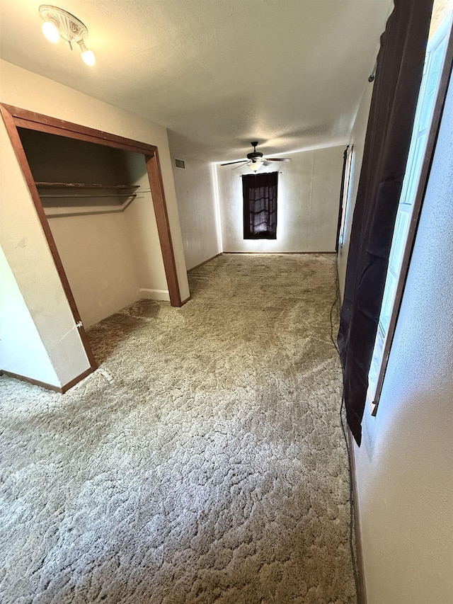 hall with carpet floors and a textured ceiling