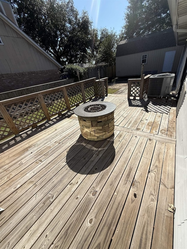 wooden terrace featuring a fire pit and central AC unit