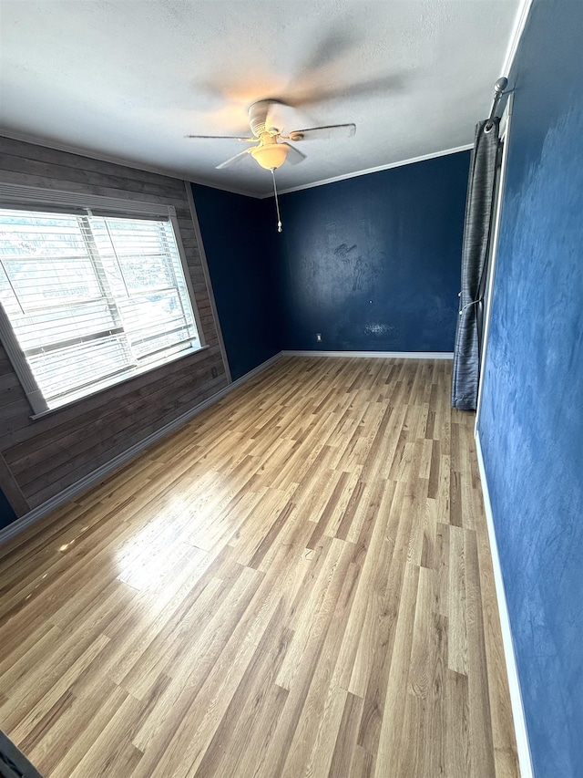 spare room with ceiling fan, light wood-type flooring, and a textured ceiling