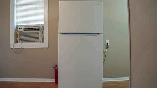 room details featuring wood-type flooring, white fridge, and cooling unit