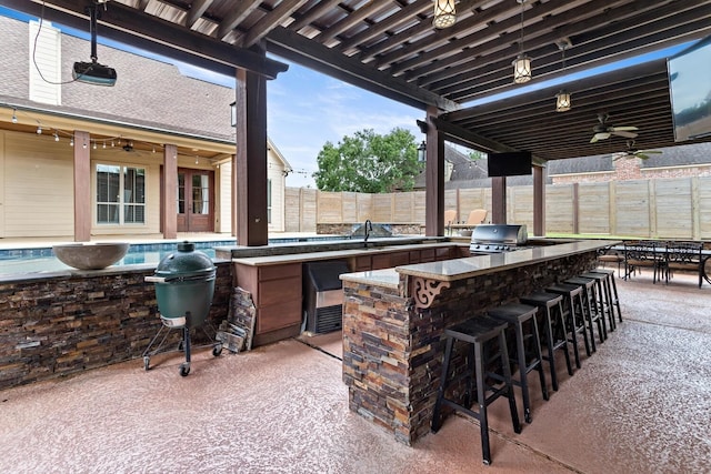 5320 Manion Way, Lumberton, TX 77657 - fenced backyard with exterior kitchen, ceiling fan, and a patio area