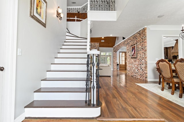 5320 Manion Way, Lumberton, TX 77657 - stairs with wood finished floors, ornamental molding, and brick wall