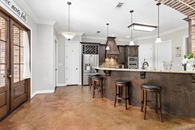 5320 Manion Way, Lumberton, TX 77657 - kitchen featuring stainless steel appliances, dark brown cabinetry, concrete floors, a kitchen breakfast bar, and pendant lighting