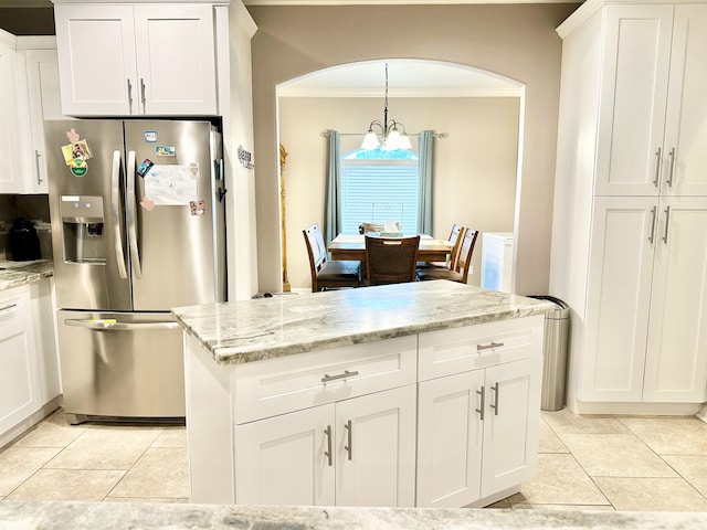 kitchen with stainless steel refrigerator with ice dispenser, white cabinetry, and ornamental molding