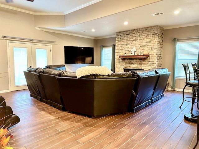 living room with a fireplace, light wood-type flooring, and crown molding