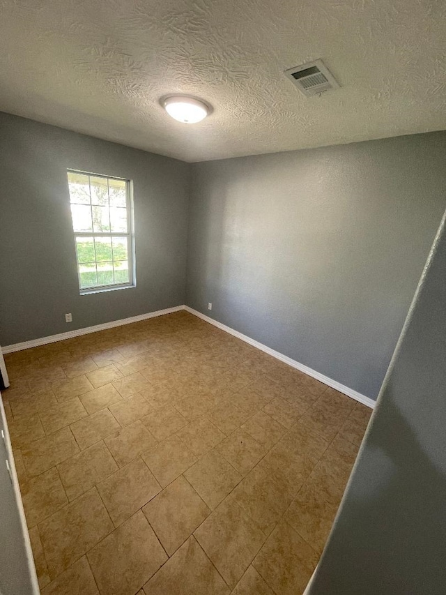 unfurnished room featuring a textured ceiling