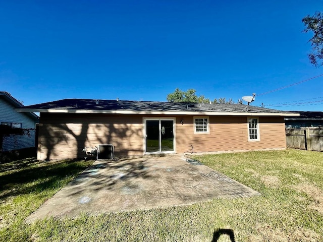 rear view of property with a patio and a lawn