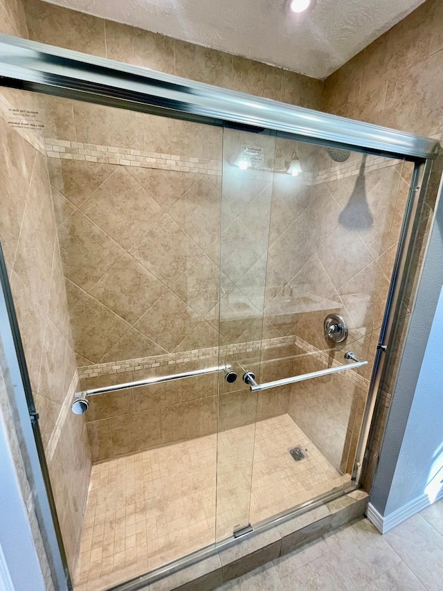 bathroom featuring tile patterned floors and a shower with shower door