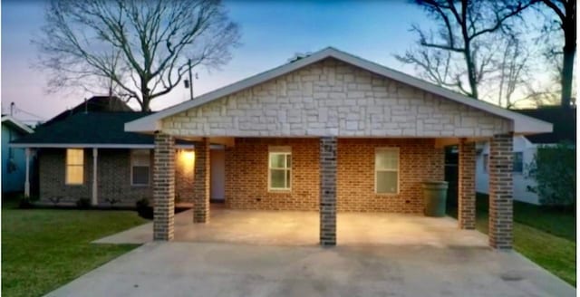 view of front of property with a carport and a yard