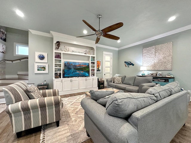 living room with ceiling fan, light hardwood / wood-style flooring, crown molding, and built in features