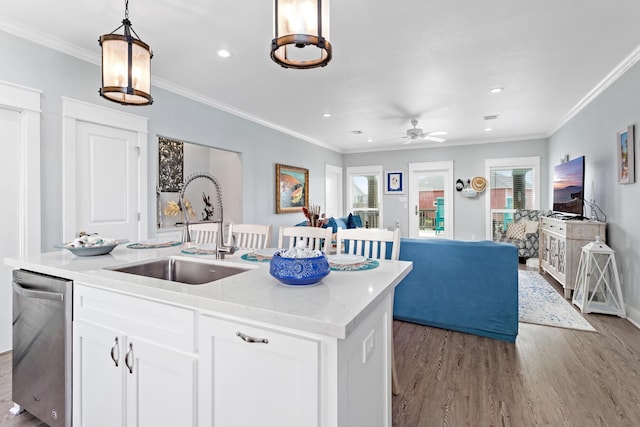 kitchen with a kitchen island with sink, sink, pendant lighting, dishwasher, and white cabinets