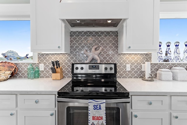 kitchen with white cabinets, custom range hood, electric range, and backsplash