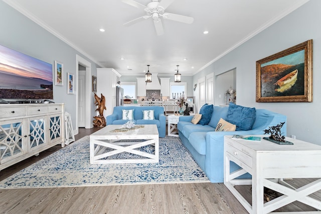 living room with hardwood / wood-style floors, ceiling fan, and crown molding