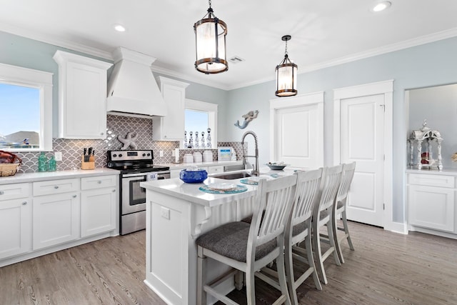 kitchen with white cabinetry, stainless steel electric range oven, pendant lighting, and custom exhaust hood