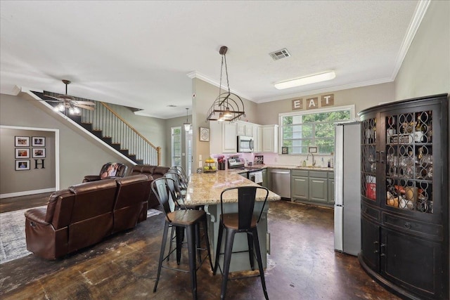 265 Callie Ln, Orange, TX 77632 - kitchen featuring stainless steel appliances, a peninsula, a sink, open floor plan, and a breakfast bar