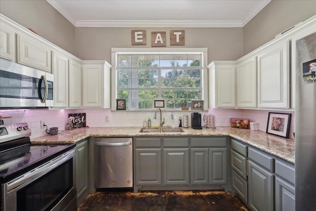265 Callie Ln, Orange, TX 77632 - kitchen featuring appliances with stainless steel finishes, a sink, gray cabinetry, backsplash, and ornamental molding