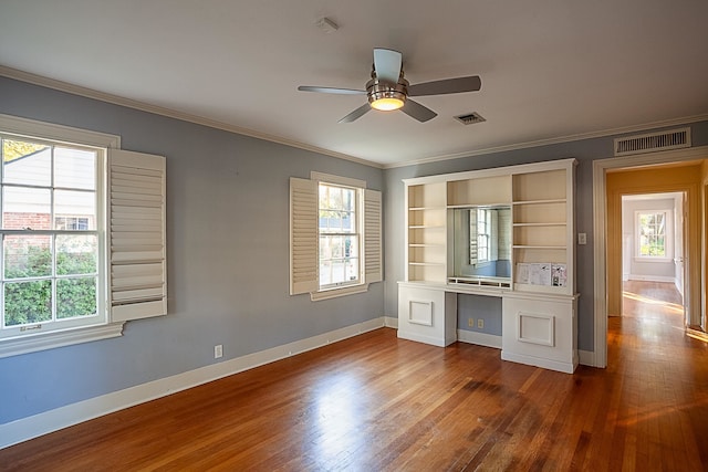 interior space with hardwood / wood-style flooring, ceiling fan, built in desk, and ornamental molding