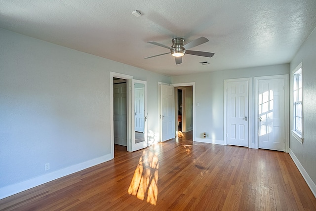 interior space with wood-type flooring, a textured ceiling, and ceiling fan