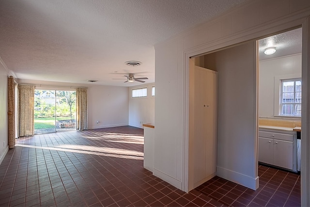 unfurnished room with ceiling fan and a textured ceiling