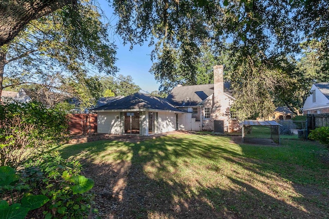 back of house with a lawn