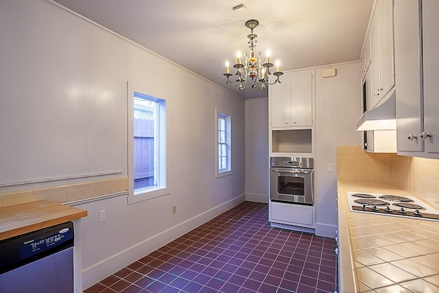 kitchen featuring appliances with stainless steel finishes, backsplash, an inviting chandelier, white cabinets, and hanging light fixtures